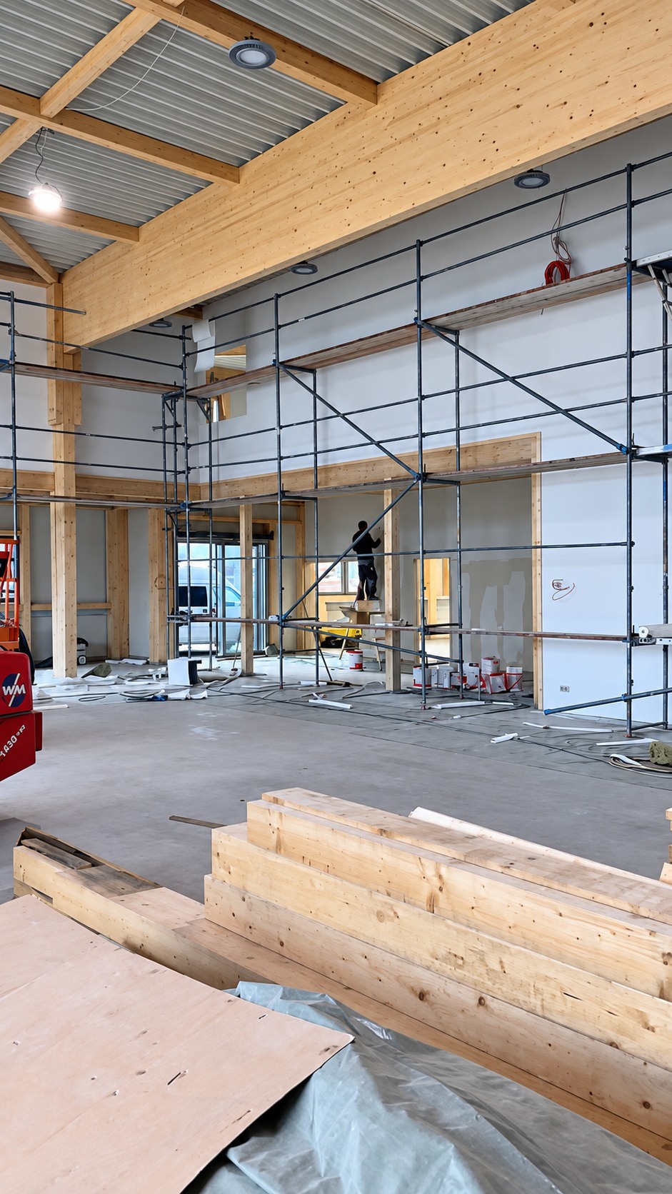 Gewerbehalle während des Innenausbaus mit Gerüst und neuen Trockenbauwänden